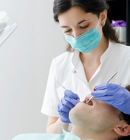 Dentist performing teeth cleaning on patient